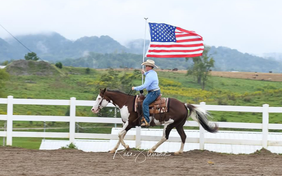 Flag-bearing male on horseback at the Russell County Fair and Horse Show