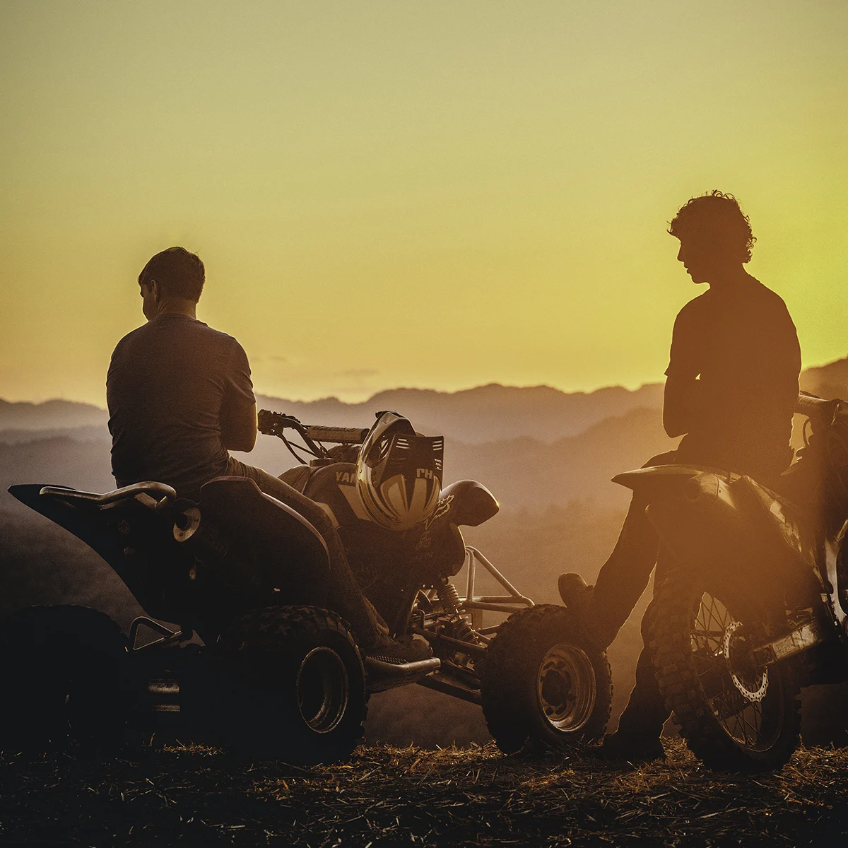 atv-dirt-bike-riders-scenic-sunset-mountains-virginia.jpg Two trail riders sit on an ATV and a dirt bike at golden hour sunset, looking out over the mountain ridges of Southwest Virginia.