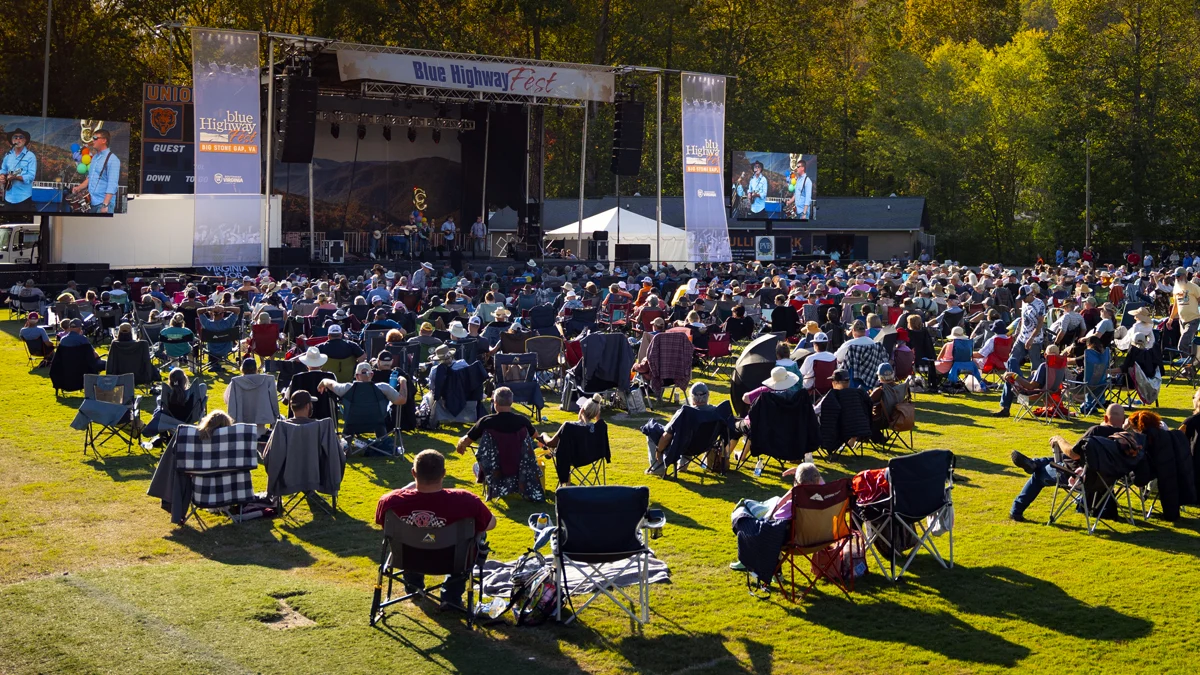 A large crowd in lawn chairs watches the main stage at Blue Highway Fest in Bullitt Park, Big Stone Gap, Virginia.