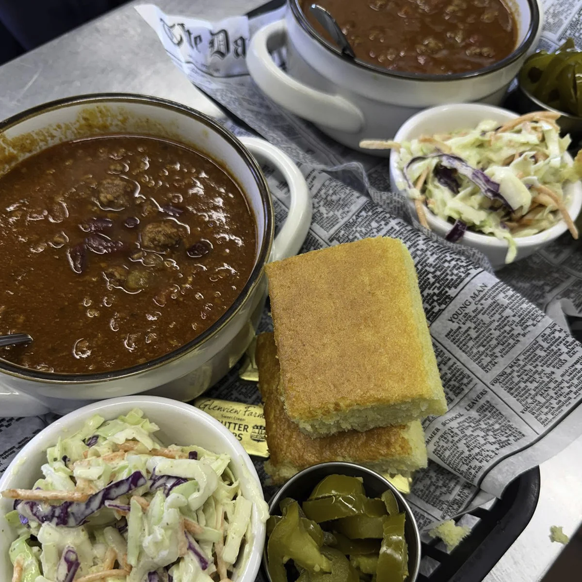 Bowls of chili with cornbread, coleslaw, and pickles served at Fisher & Company restaurant in Tazewell, Virginia.