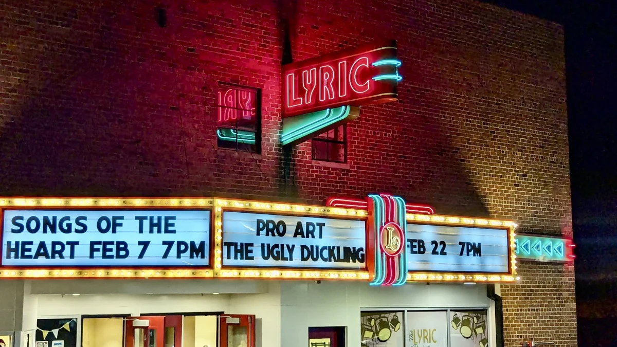 The Lyric Theatre's neon sign and marquee light up at night in St. Paul, Virginia, listing upcoming performances.