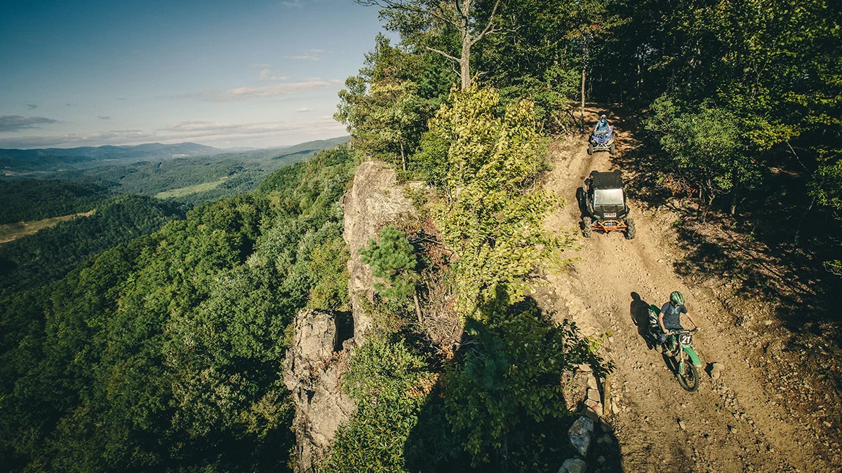 off-road-overlook-stone-mountain-trail-spearhead-trails-virginia.jpg Off-road vehicles and a dirt bike travel along a mountain ridgeline trail overlooking the forests of Southwest Virginia.