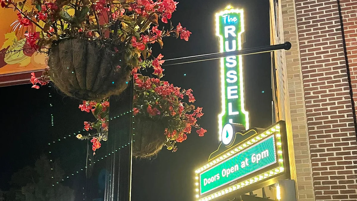 The Russell Theatre neon sign and lit marquee glow at night in Lebanon, Virginia.