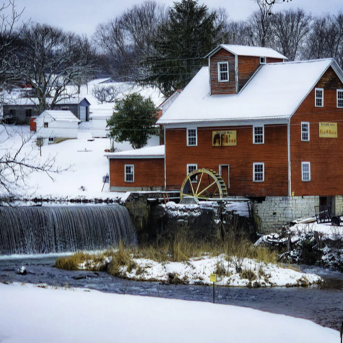 Taylor's Mill, a red water-powered gristmill with a wooden waterwheel beside a snow-covered dam waterfall in Tazewell County, Virginia