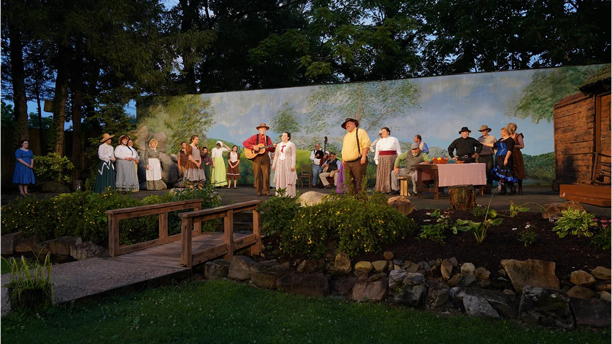The full cast performs on the outdoor stage against a painted mountain backdrop during the Trail of the Lonesome Pine drama in Big Stone Gap, Virginia.