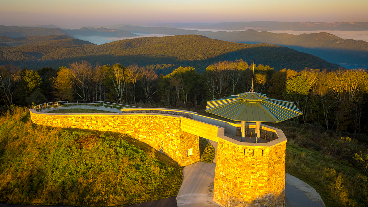 Stone observation tower and accessible ramp at High Knob glowing at sunset above fog-filled valleys near Norton, Virginia